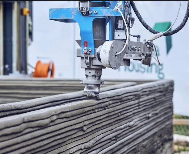 A construction 3D printer laying down a layered concrete wall